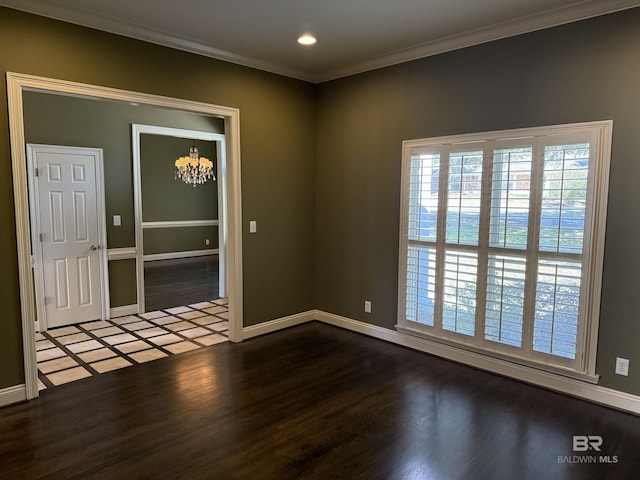 unfurnished room with baseboards, ornamental molding, wood finished floors, and an inviting chandelier