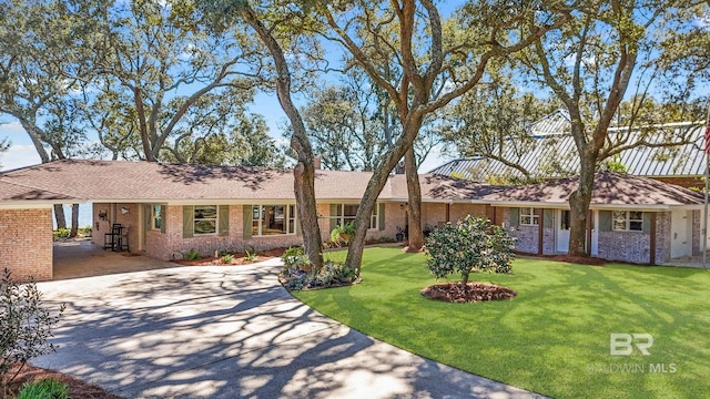 single story home with a front yard, brick siding, and driveway