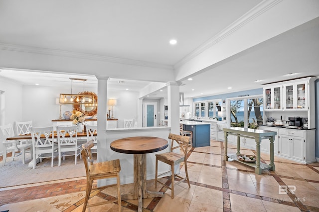 interior space with crown molding, recessed lighting, decorative columns, and baseboards