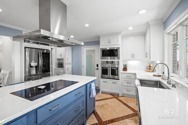 kitchen featuring island range hood, white cabinets, ornamental molding, stainless steel appliances, and blue cabinetry