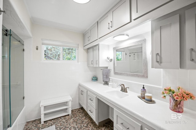 full bathroom with tile walls, vanity, and walk in shower