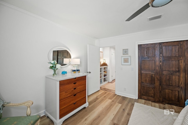 entrance foyer with light wood-type flooring, baseboards, visible vents, and crown molding