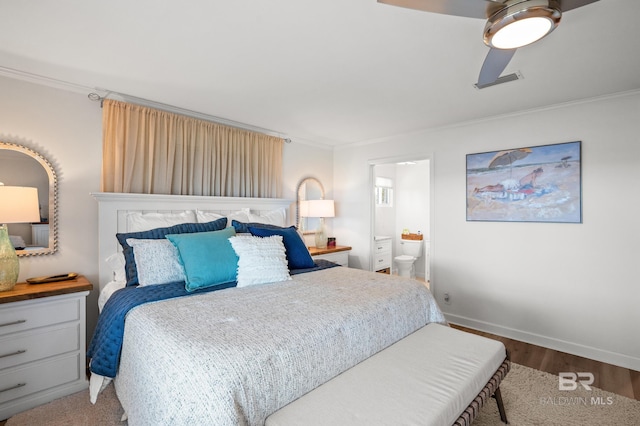 bedroom with ensuite bath, baseboards, visible vents, and ornamental molding