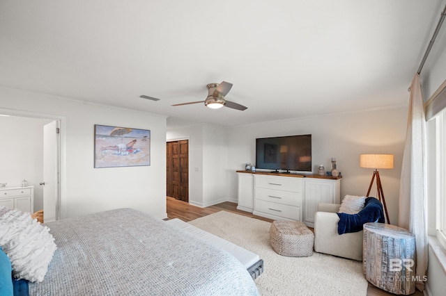 bedroom featuring light wood-type flooring, baseboards, visible vents, and a ceiling fan