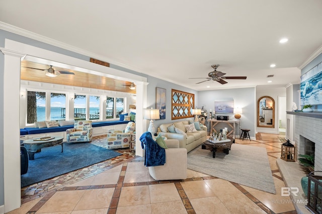 living room featuring a fireplace, recessed lighting, a water view, ornamental molding, and baseboards