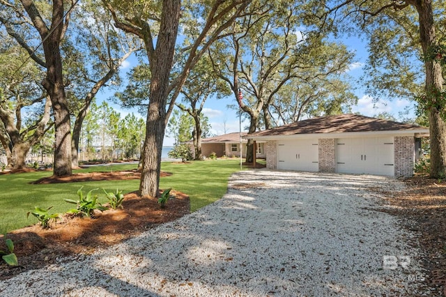 ranch-style home featuring driveway, a garage, a front lawn, and brick siding