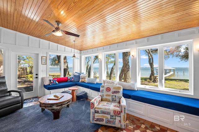 sunroom / solarium with vaulted ceiling, a water view, wooden ceiling, and a ceiling fan