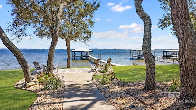 view of dock featuring a water view and a yard