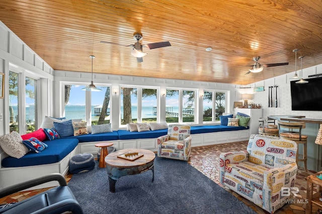 sunroom with ceiling fan, plenty of natural light, and wooden ceiling