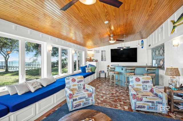 sunroom / solarium featuring a water view, wooden ceiling, and ceiling fan