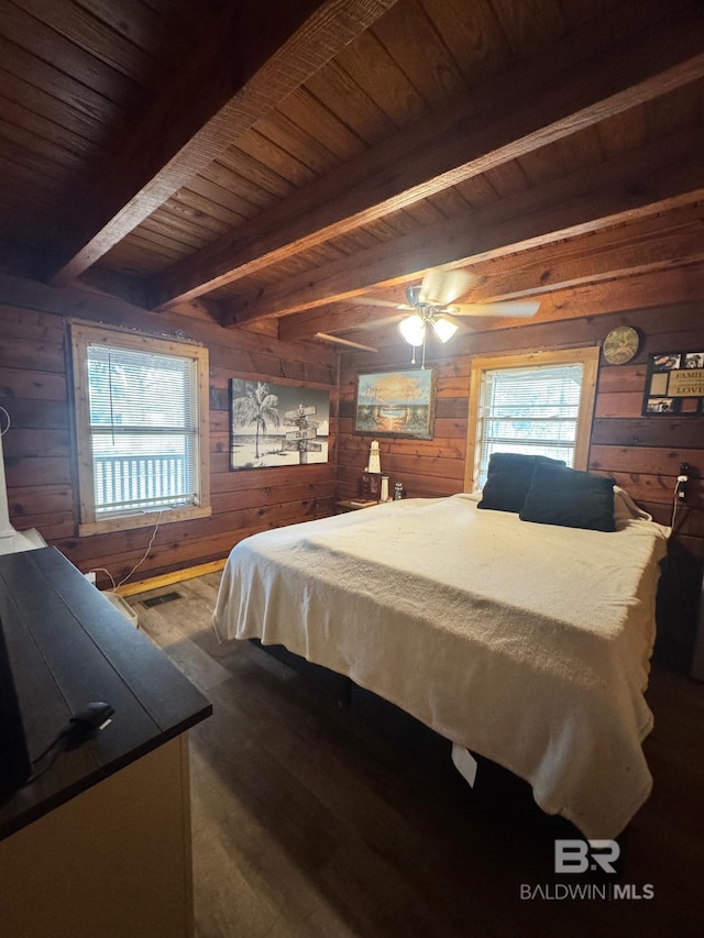 bedroom with wooden ceiling, multiple windows, and wood walls