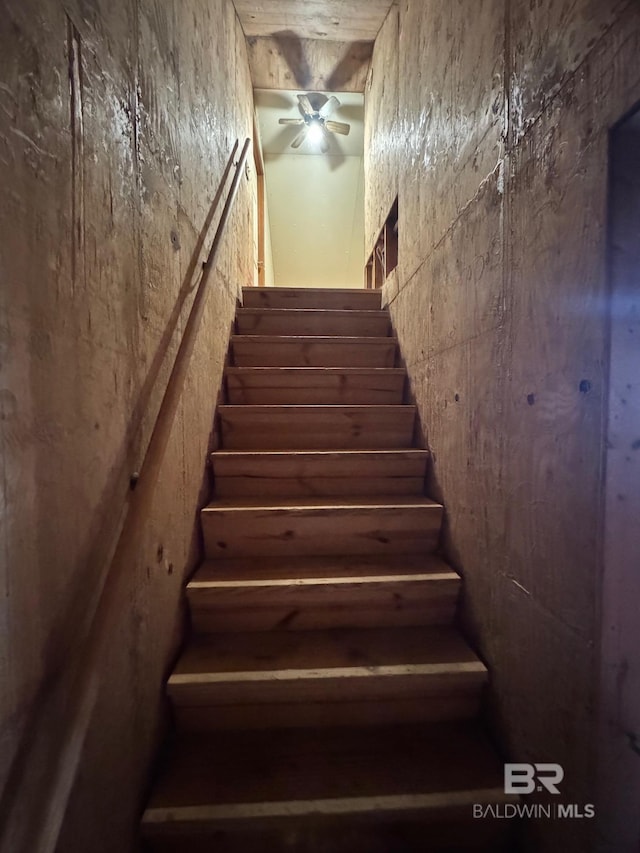 stairway featuring a ceiling fan