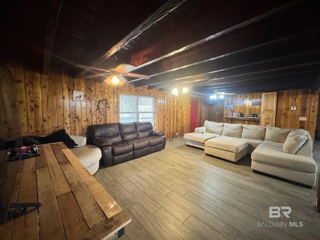 living room featuring wood walls, ceiling fan, beam ceiling, and wood finished floors