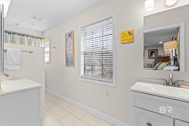 full bath with ensuite bath, visible vents, two vanities, and a sink