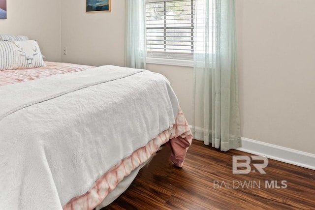 bedroom featuring dark wood-style floors and baseboards