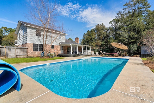 view of swimming pool with a lawn, fence, and a fenced in pool