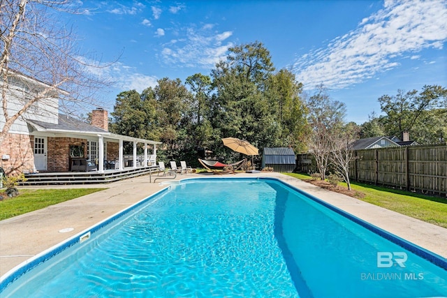 view of swimming pool with a fenced backyard, an exterior structure, a fenced in pool, and an outdoor structure