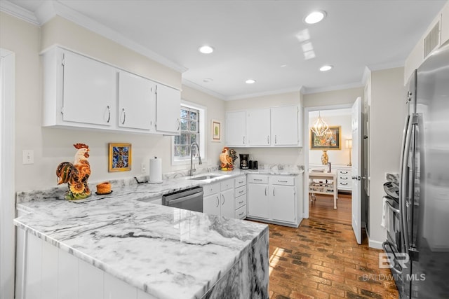 kitchen featuring white cabinets, a peninsula, brick floor, stainless steel appliances, and a sink