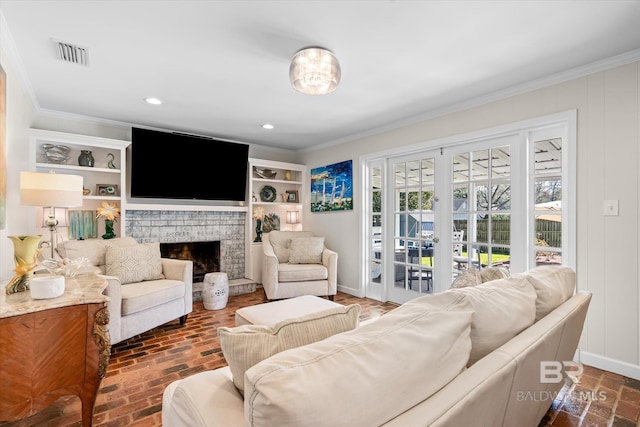 living room featuring brick floor, a fireplace, visible vents, baseboards, and crown molding