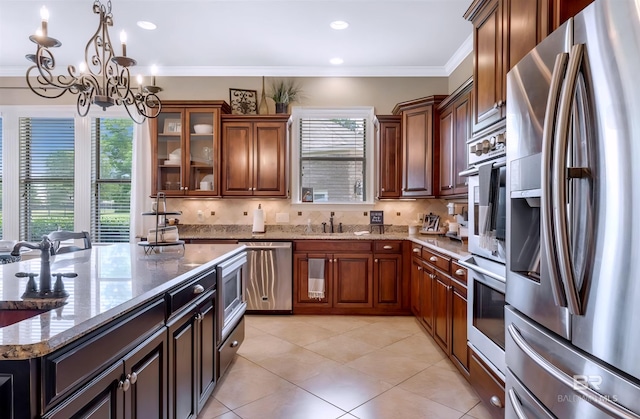 kitchen with stainless steel appliances, a sink, a wealth of natural light, and crown molding