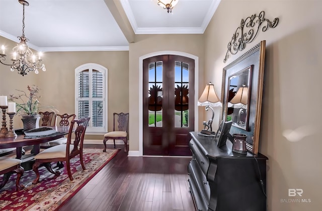 foyer entrance featuring arched walkways, a chandelier, french doors, ornamental molding, and dark wood finished floors