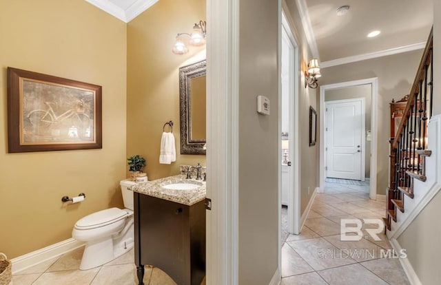 half bathroom featuring toilet, vanity, baseboards, ornamental molding, and tile patterned floors