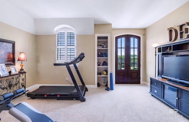 workout room with arched walkways, french doors, light colored carpet, and baseboards