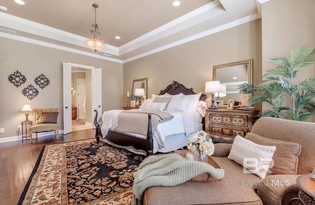 bedroom with ornamental molding, a raised ceiling, and hardwood / wood-style flooring