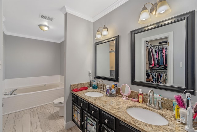 bathroom with toilet, crown molding, vanity, a tub, and hardwood / wood-style floors