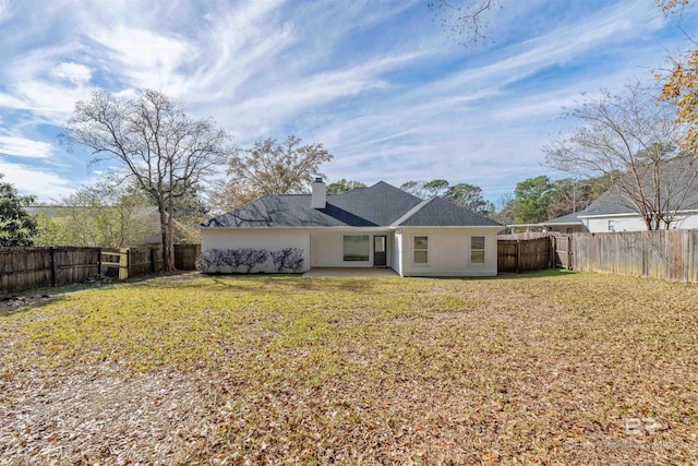 back of property featuring a lawn