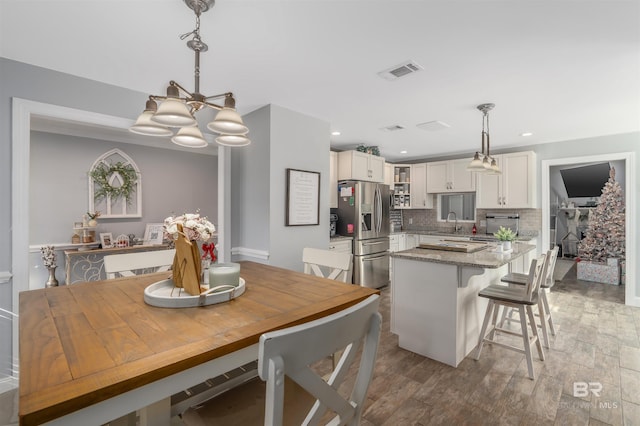 dining area with an inviting chandelier, sink, and hardwood / wood-style floors