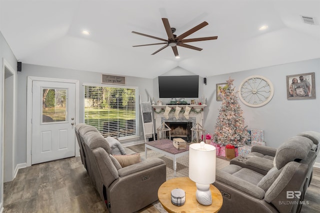 living room with hardwood / wood-style flooring, ceiling fan, and vaulted ceiling