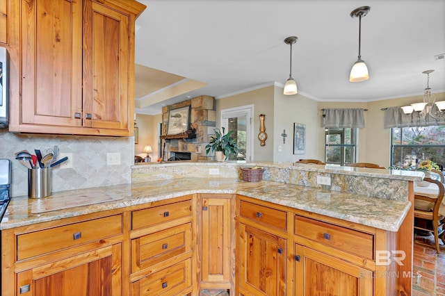 kitchen with crown molding, pendant lighting, backsplash, and kitchen peninsula