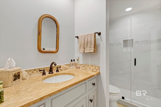 bathroom with an enclosed shower, vanity, tasteful backsplash, and toilet