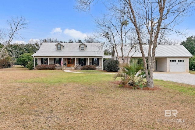 cape cod home with a garage, covered porch, and a front lawn