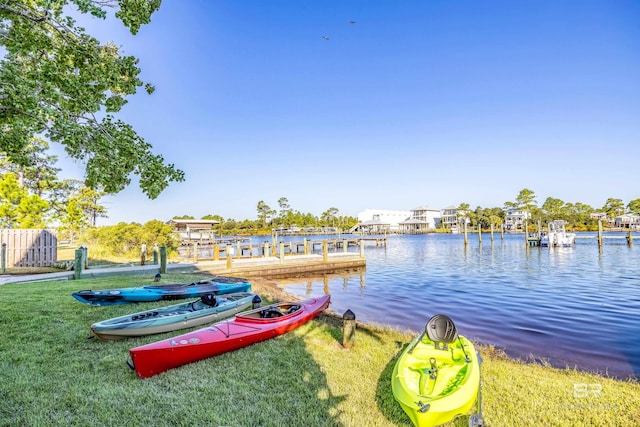 view of dock with a water view and a lawn