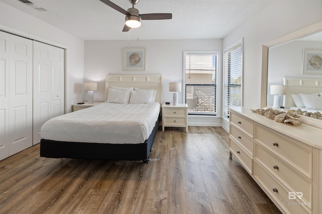 bedroom featuring a closet, ceiling fan, a textured ceiling, and dark hardwood / wood-style flooring