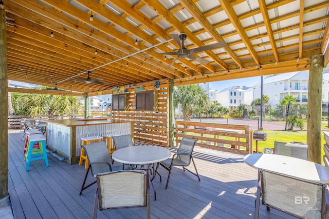 deck featuring an outdoor bar and ceiling fan