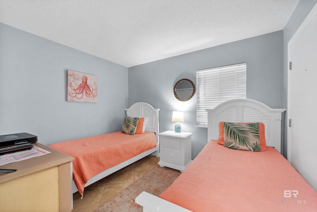 bedroom featuring light tile patterned flooring and a textured ceiling