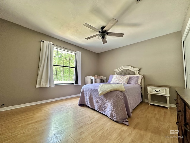 bedroom featuring baseboards, ceiling fan, and wood finished floors