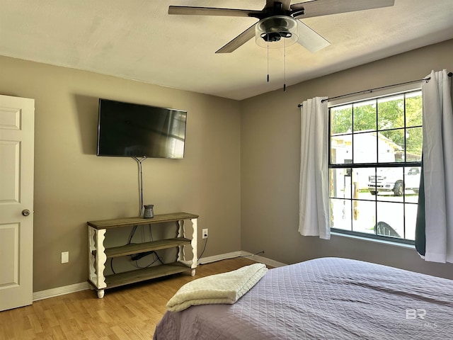 bedroom featuring baseboards, ceiling fan, and light wood-type flooring