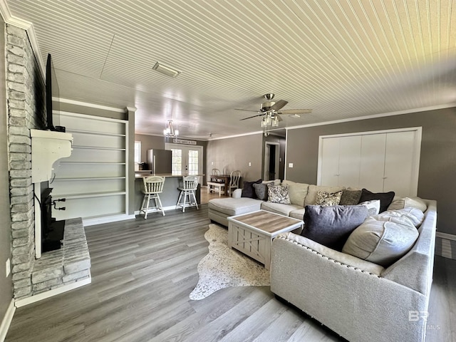 living area featuring a ceiling fan, baseboards, and wood finished floors