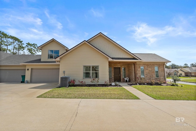 view of front facade with central AC unit, driveway, an attached garage, a shingled roof, and a front lawn