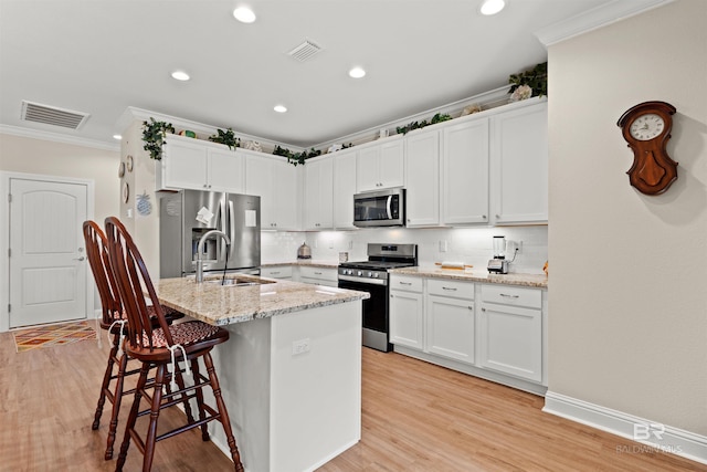 kitchen with light wood-type flooring, visible vents, a sink, stainless steel appliances, and crown molding