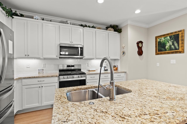 kitchen with backsplash, ornamental molding, stainless steel appliances, and a sink