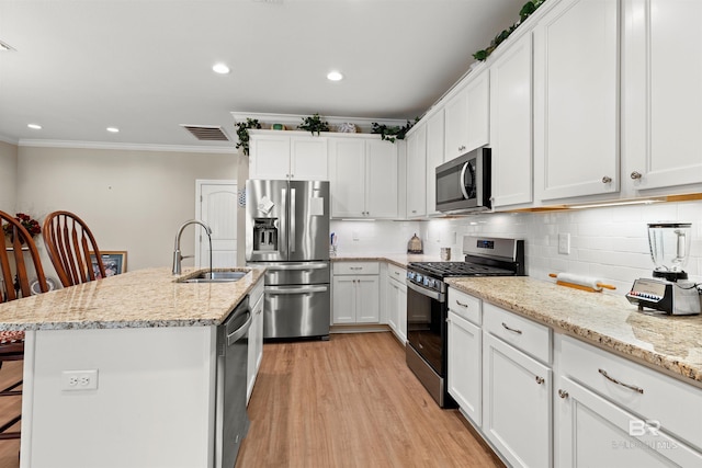 kitchen with tasteful backsplash, visible vents, ornamental molding, appliances with stainless steel finishes, and a sink