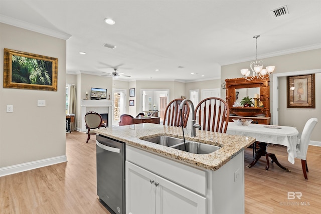 kitchen featuring a center island with sink, a sink, stainless steel dishwasher, a warm lit fireplace, and crown molding