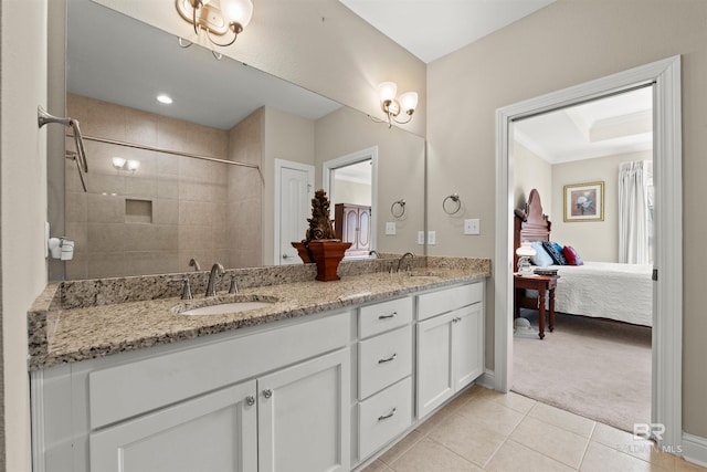 full bath featuring tile patterned flooring, double vanity, tiled shower, and a sink