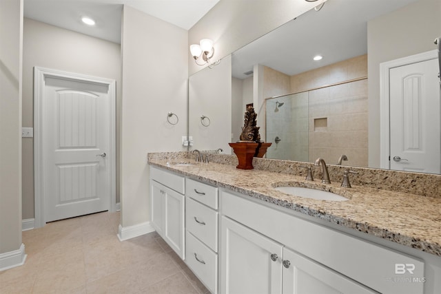 bathroom with tile patterned floors, double vanity, a stall shower, and a sink