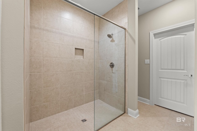 full bathroom featuring tile patterned flooring and tiled shower